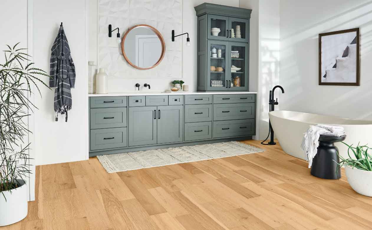 white oak engineered hardwood in modern bathroom with blue cabinets and deep soak tub